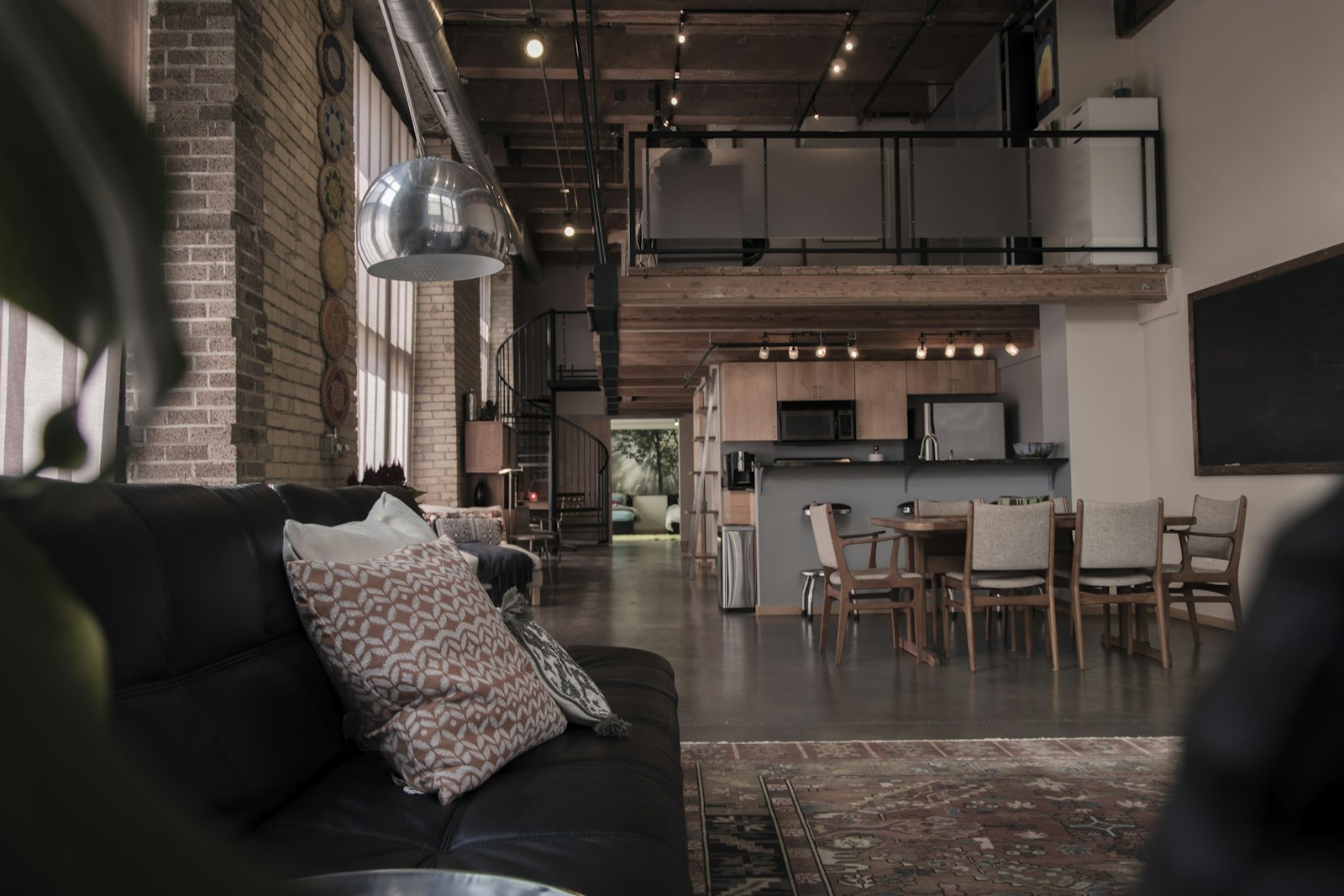 Loft avec charpente apparente, escalier en colimaçon et coin repas