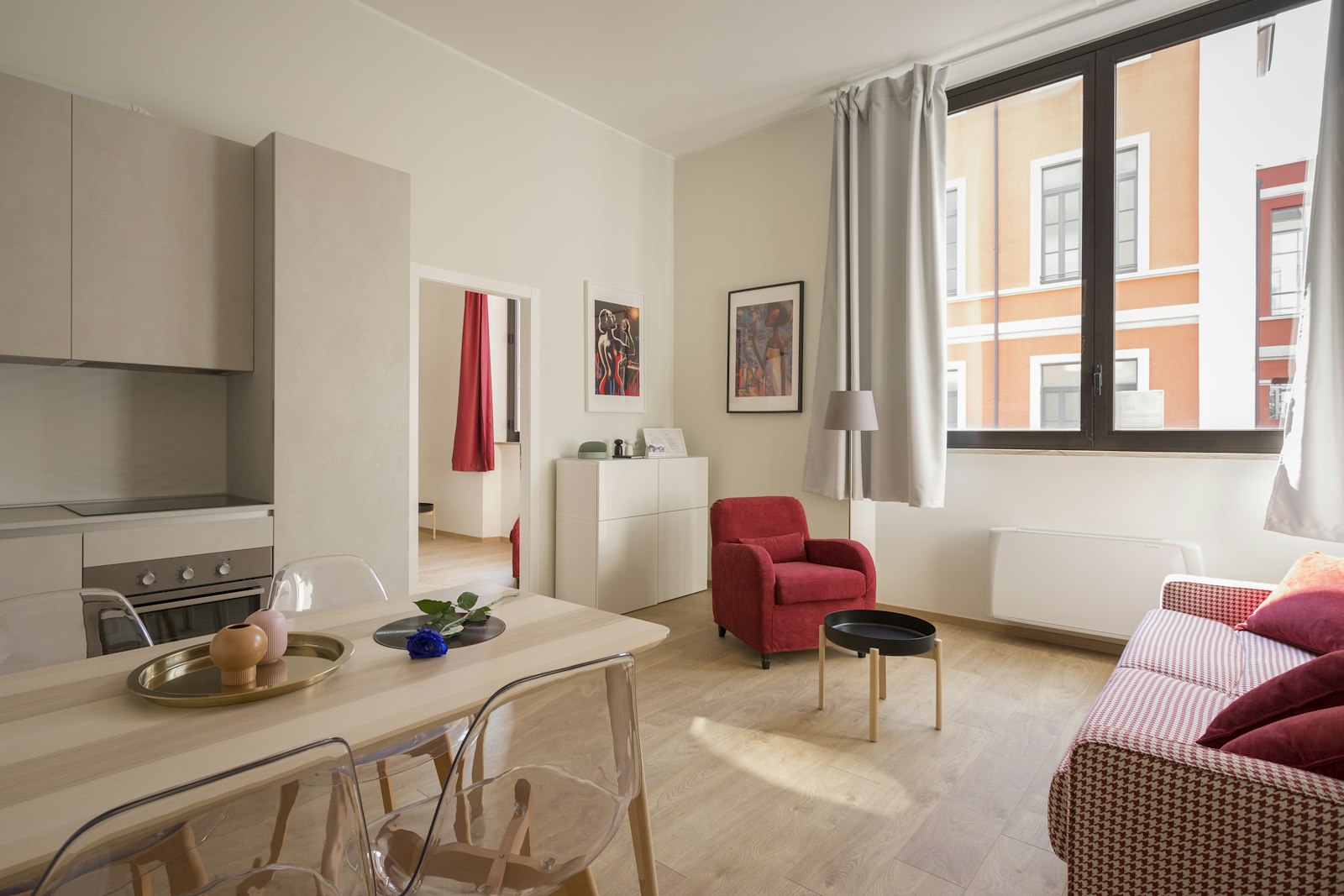 Appartement lumineux avec salon, table en bois, cuisine ouverte et grande baie vitrée